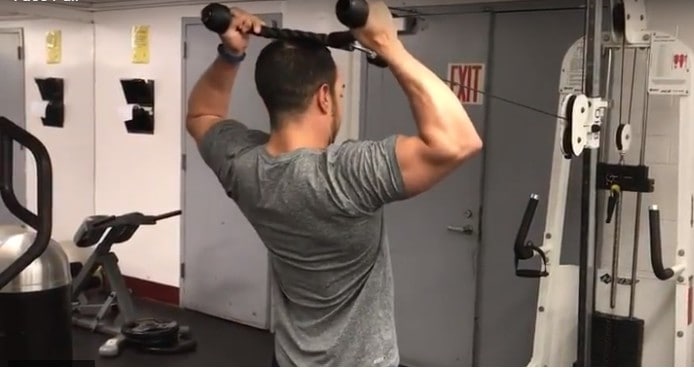 alex at the end range of the face pull with the rope above his head and arms externally rotated