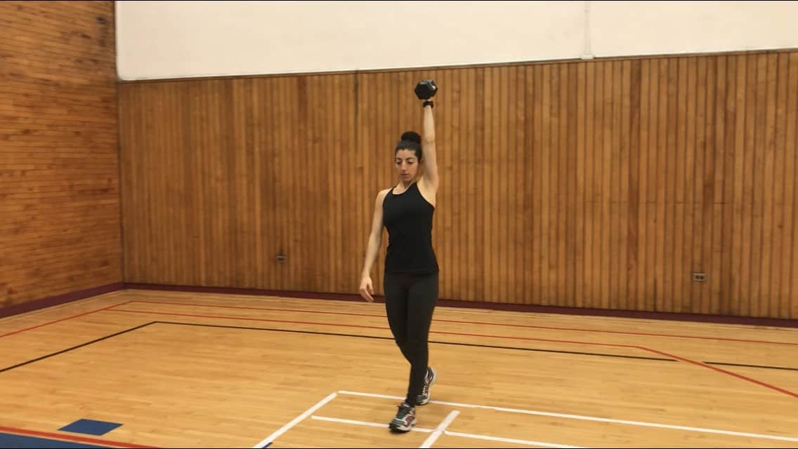 brittany walking while holding one dumbbell overhead