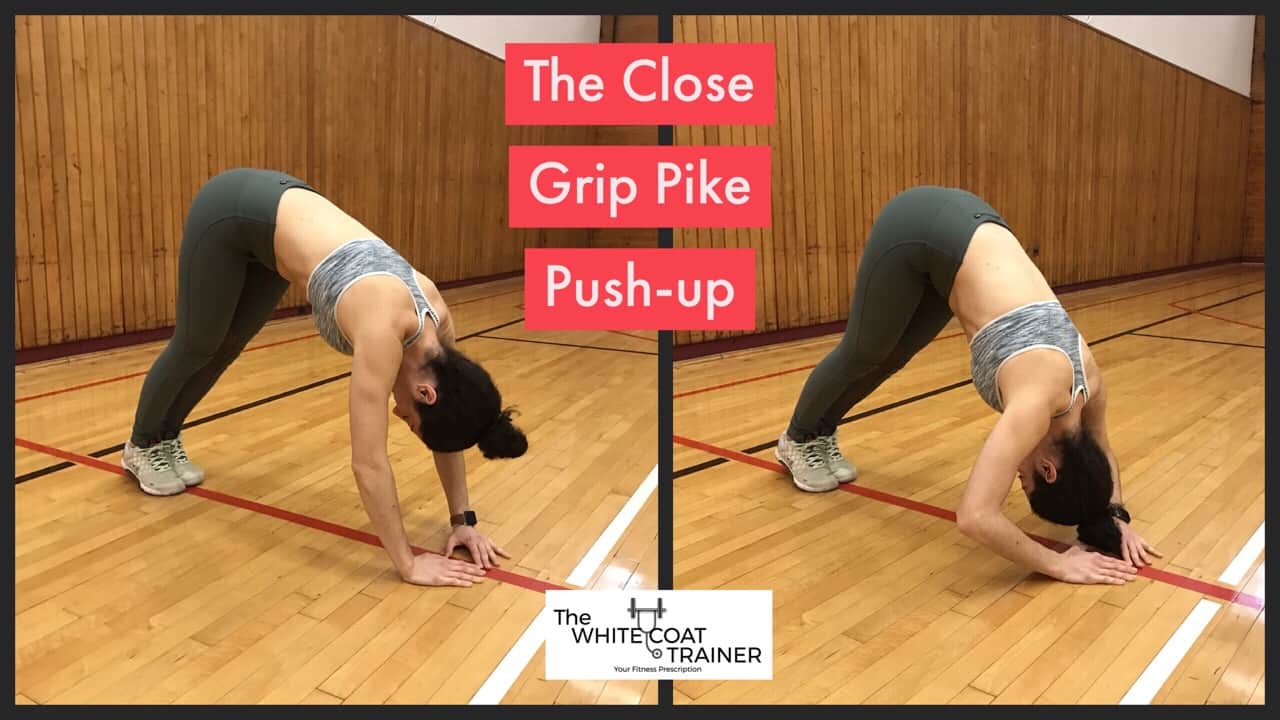 close-grip-pike-pushup-exercise: Brittany with her hands on the floor, closer than shoulder width, with her butt up toward the sky, bringing the crown of her head to the floor by bending her elbows