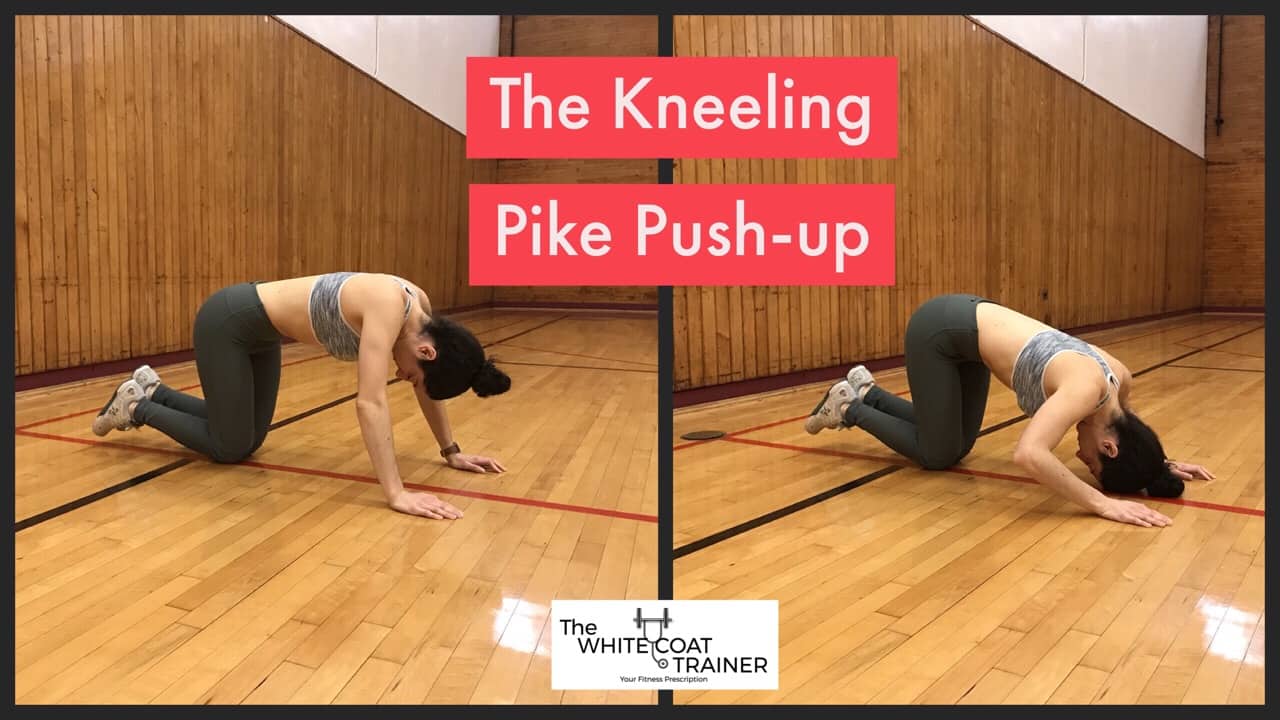 kneeling-pike-push-up-exercise: Brittany kneeling down with her hands on the floor and bringing the crown of her head toward the floor by bending at the elbows