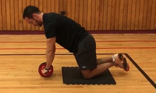 starting position of ab wheel - alex kneeling while holding on the wheel