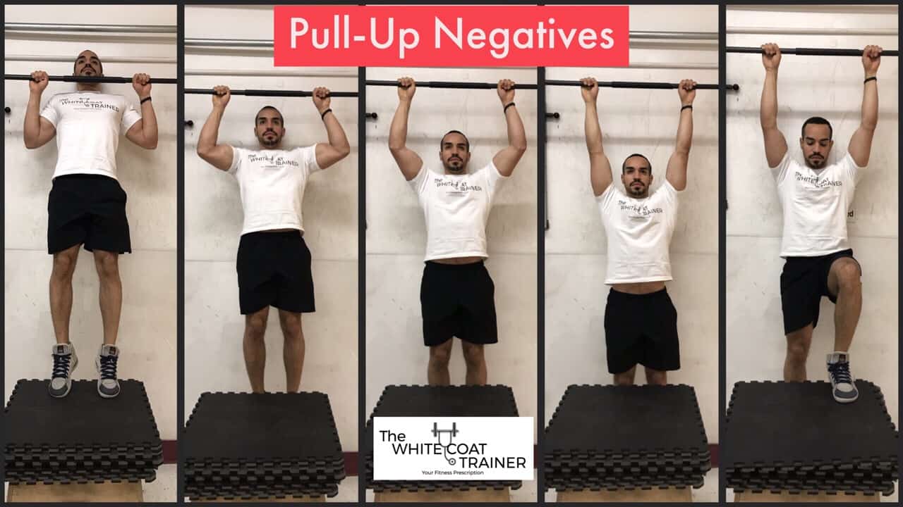 pull-up-negative-exercise: Alex slowly lowering himself from a pullup bar