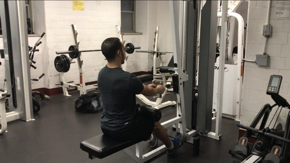 alex on a seated cable row machine grabbing the handle with a neutral spine