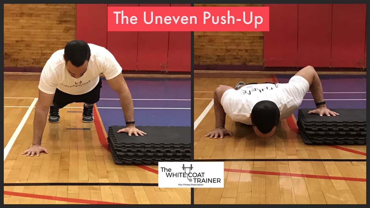 uneven-push-up-exercise: Alex doing a pushup with one hand elevated on a platform