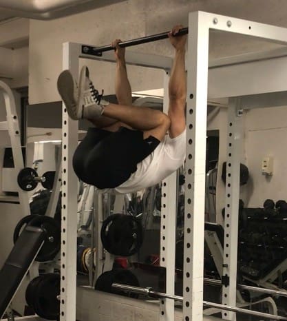 knees to elbow exercise: hanging from a bar and bringing your knees up to touch your elbows