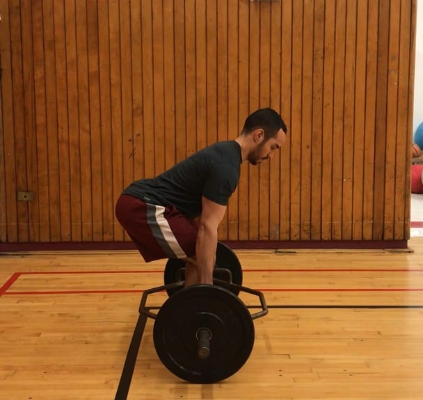 trap bar deadlift starting position, bent over with a straight back gripping the trap bar