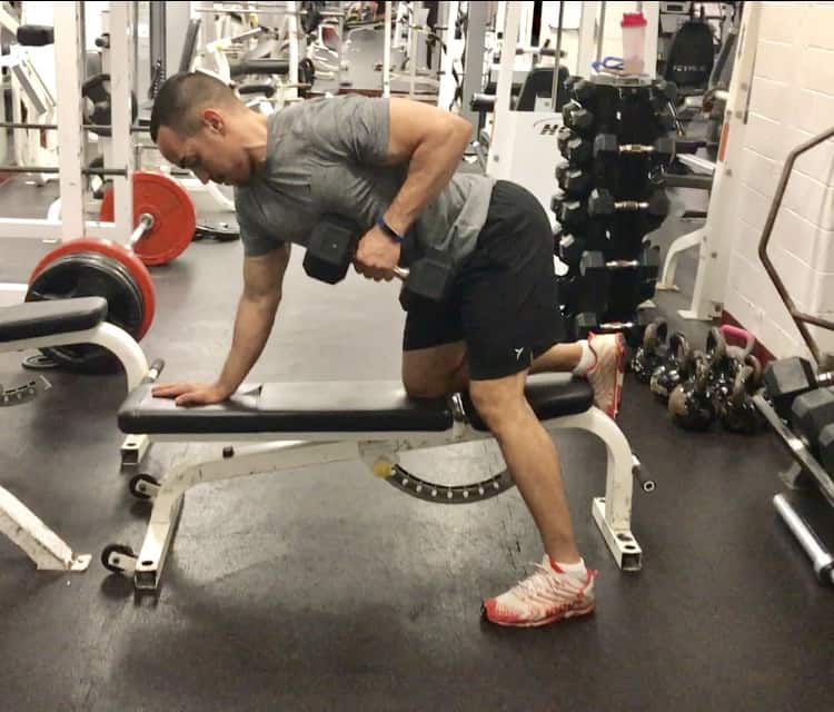 alex bent over on a bench performing a dumbbell row exercise