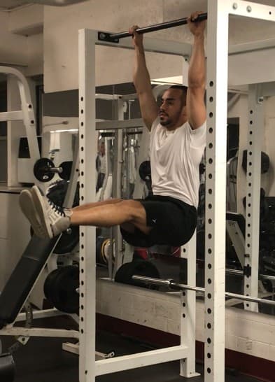 alex hanging from a bar and lifting his legs straight up to an L position