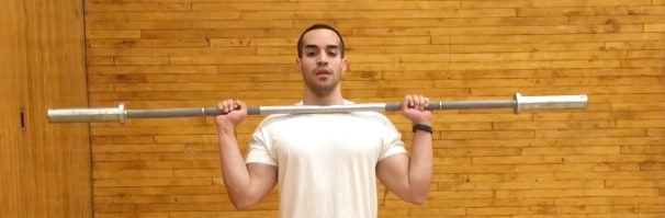 alex holding a barbell up on his shoulders while standing- front view