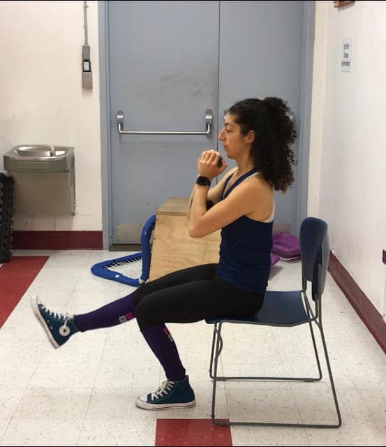 brittany demonstrating a single leg box squat holding a dumbbell at her chest
