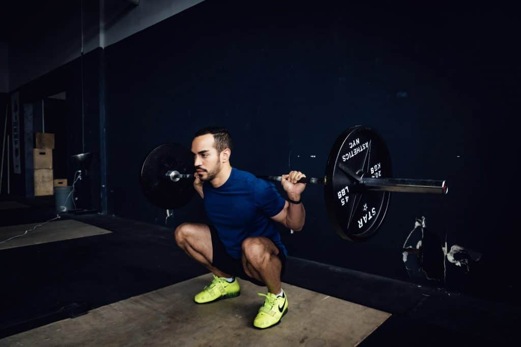 alex doing a squat with a barbell on his back