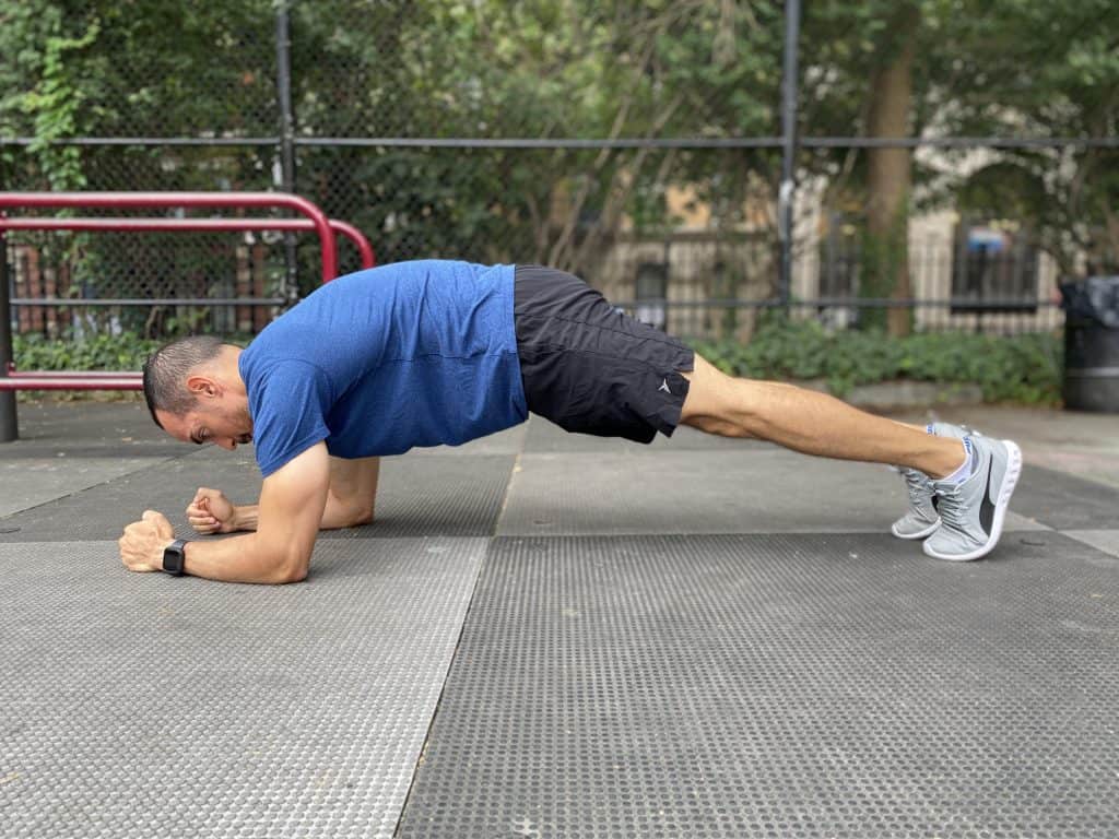 alex in a plank resting on his forearms with a rounded upper back and neutral lower back