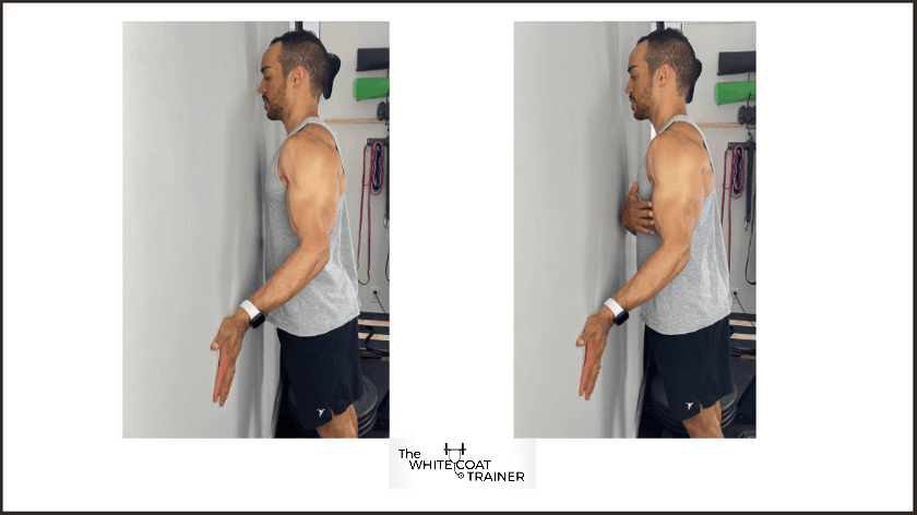 alex demonstrating the pushup with hands turned backward while standing against a wall